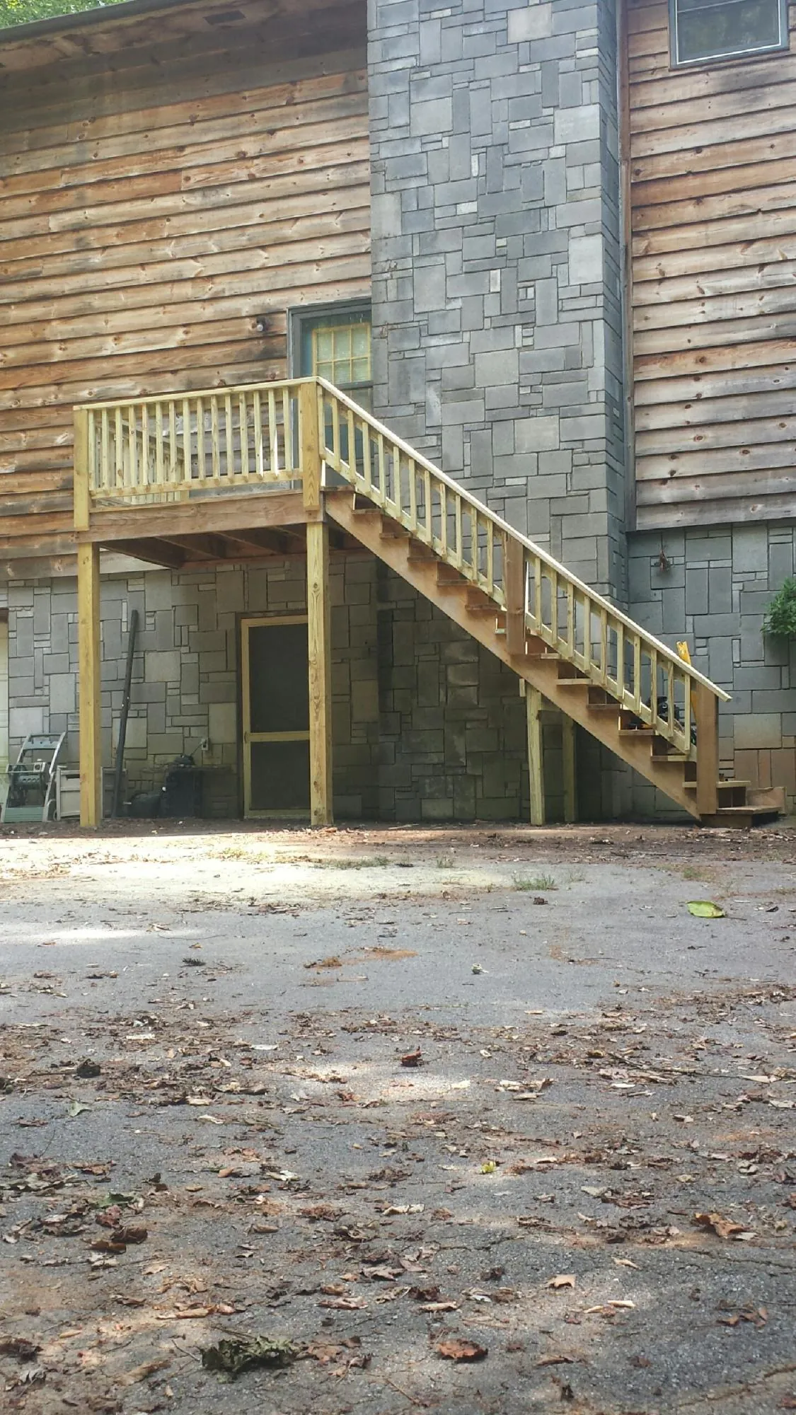 New pressure treated deck and stair landing on a log home in Windsor